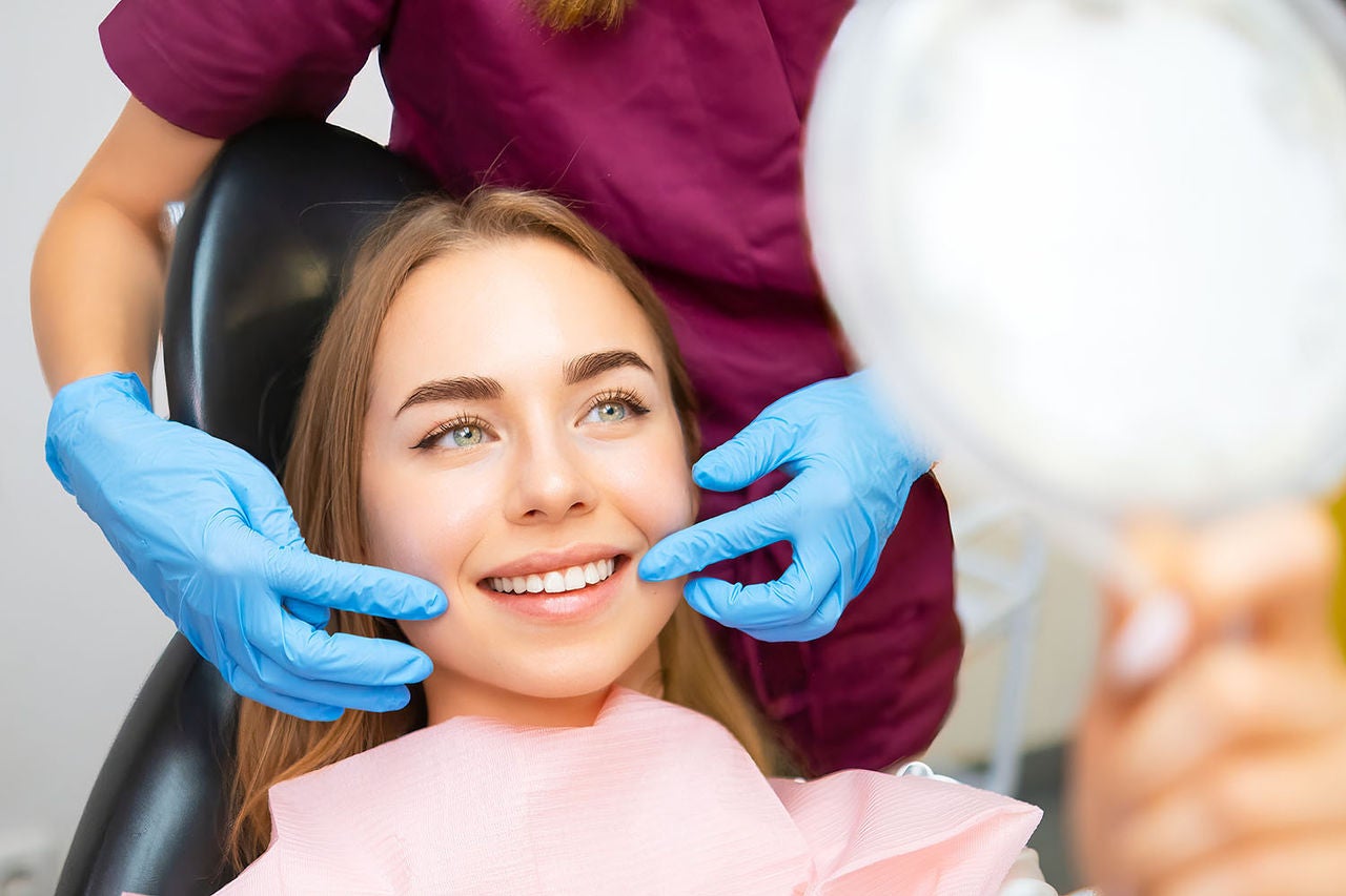 dentist demonstrates perfect smile patient after