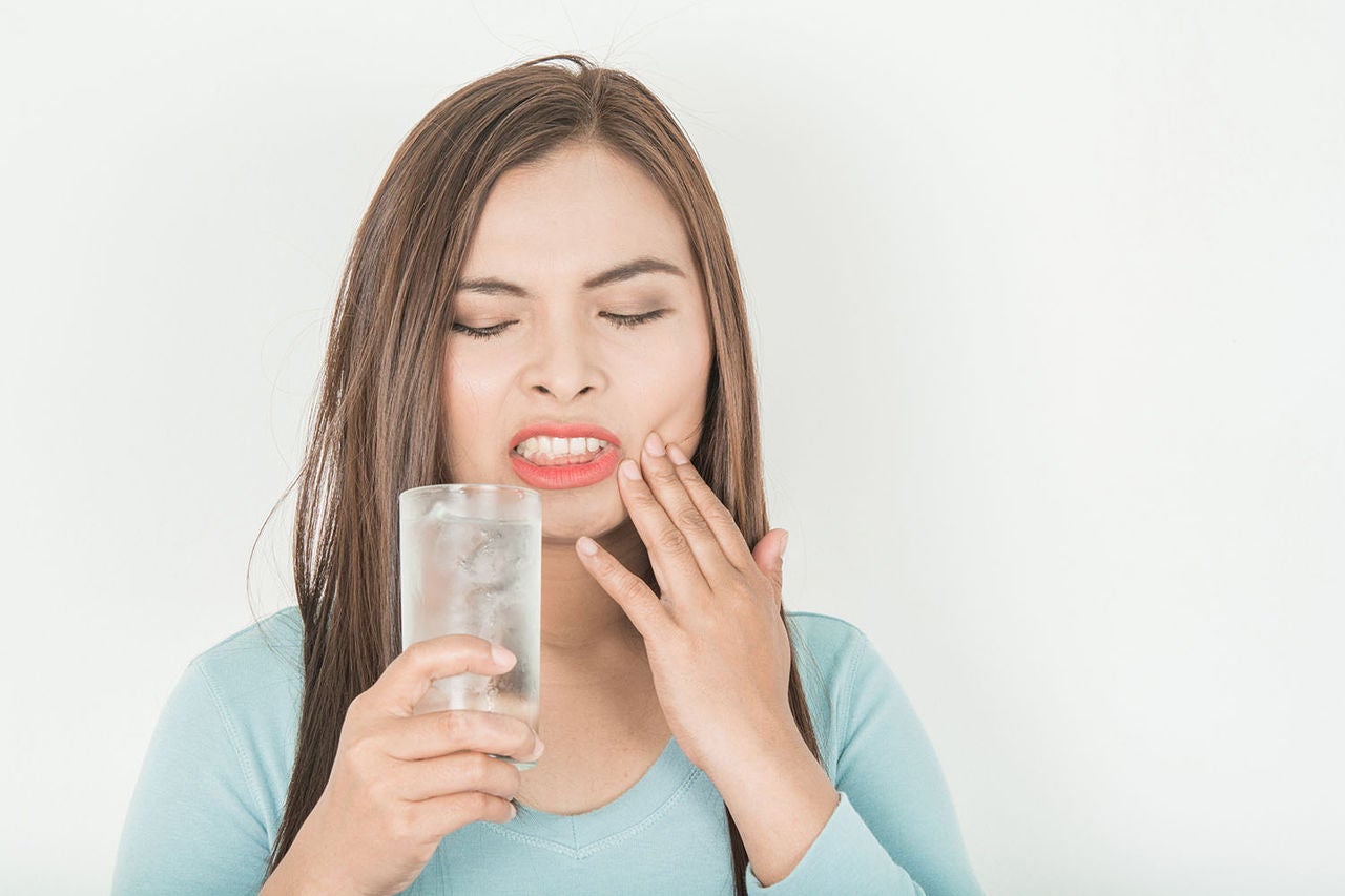 sensitive teeth woman glass cold water