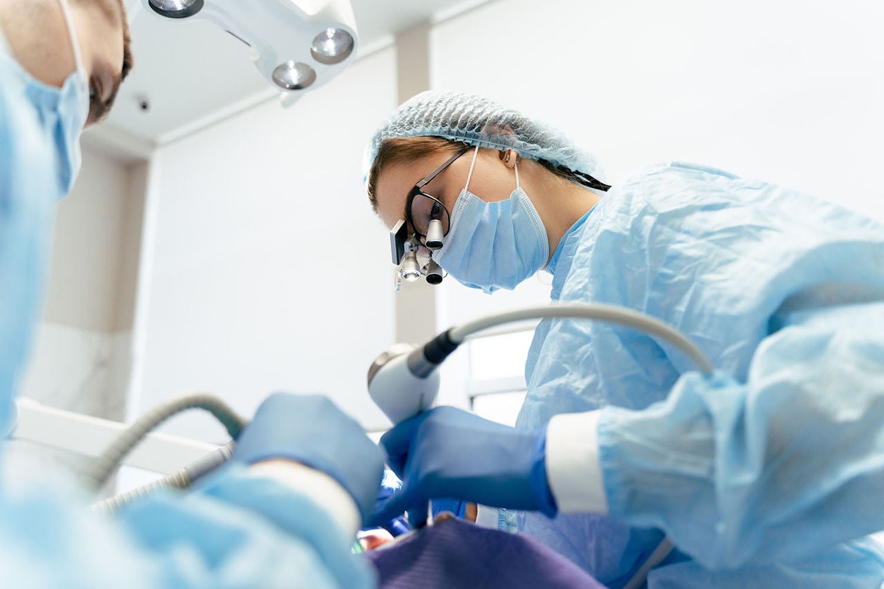 portrait female dentist binoculars surgical suit