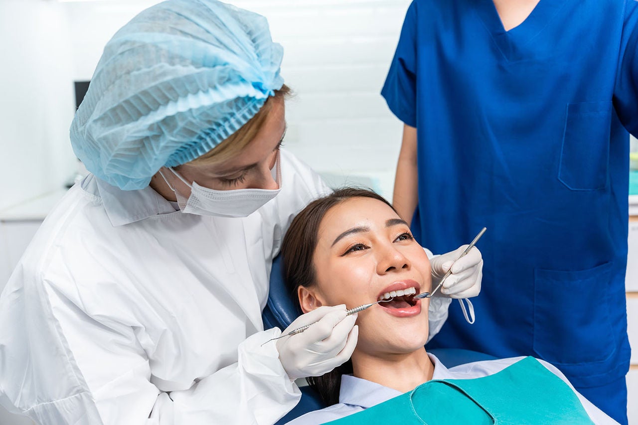 caucasian dentist examine tooth young girl