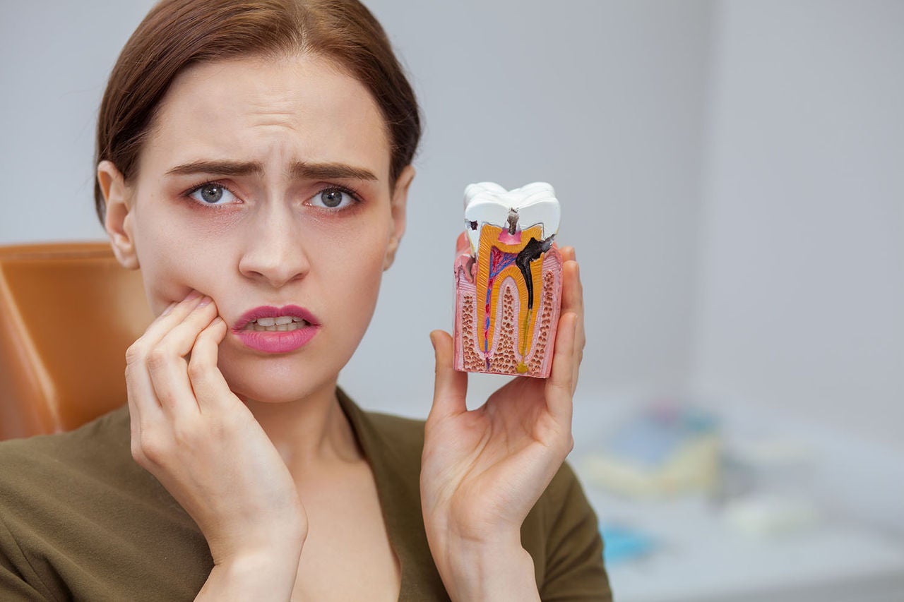 young woman suffering toothache looking camera