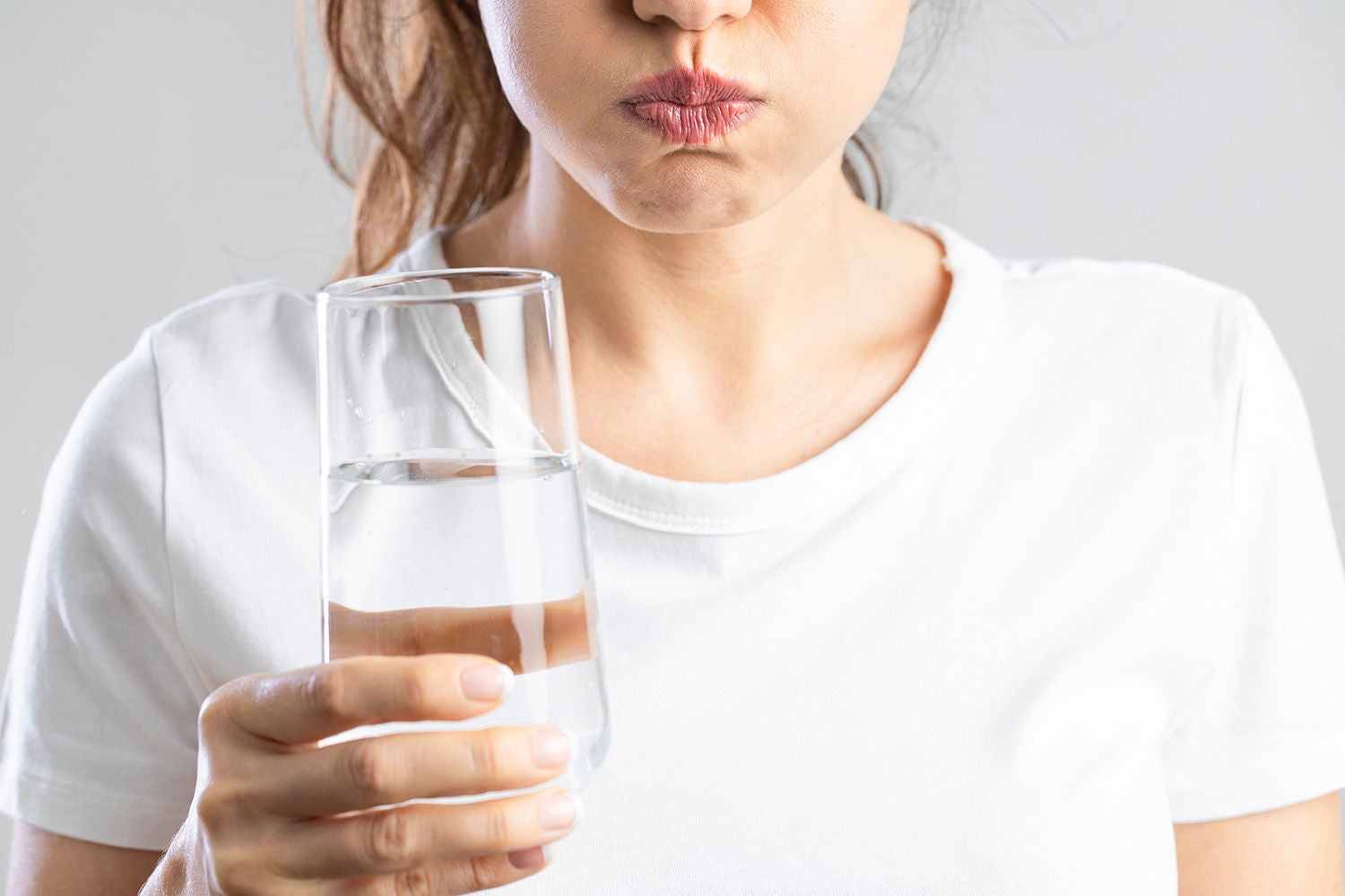 young woman gargling while using mouthwash