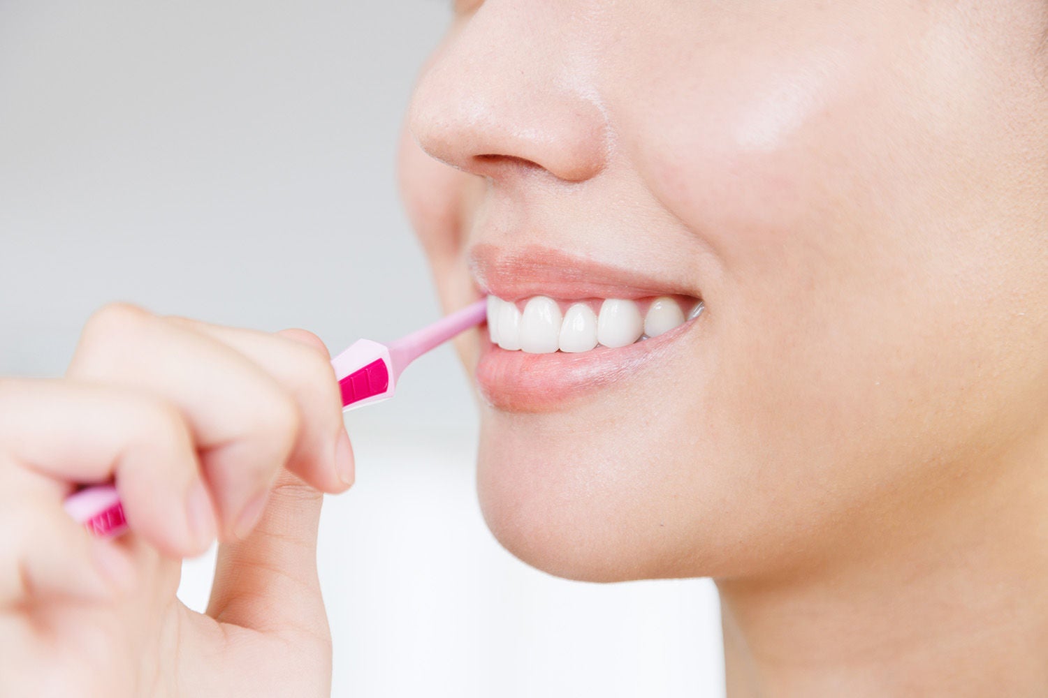 young asian woman brushing her teeth
