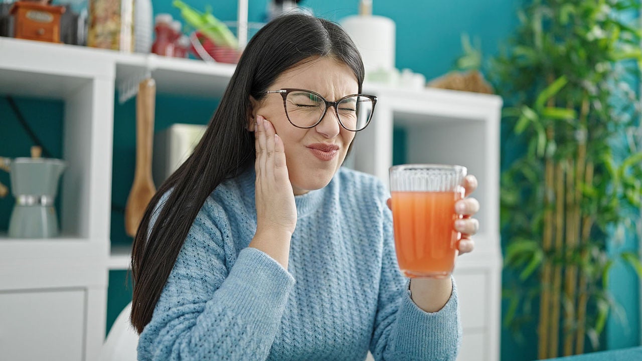 young hispanic woman drinking juice pain