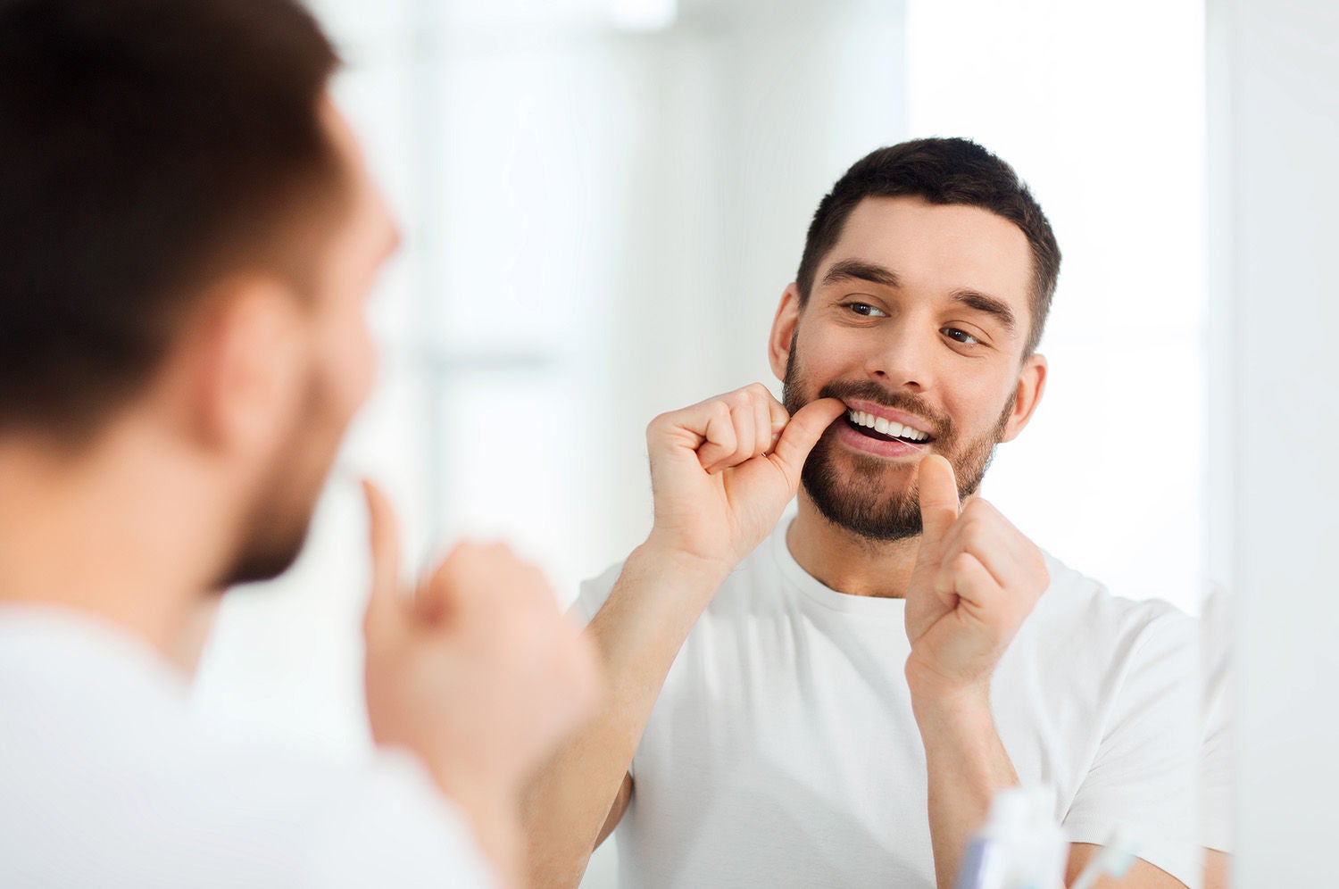 man dental floss cleaning teeth bathroom